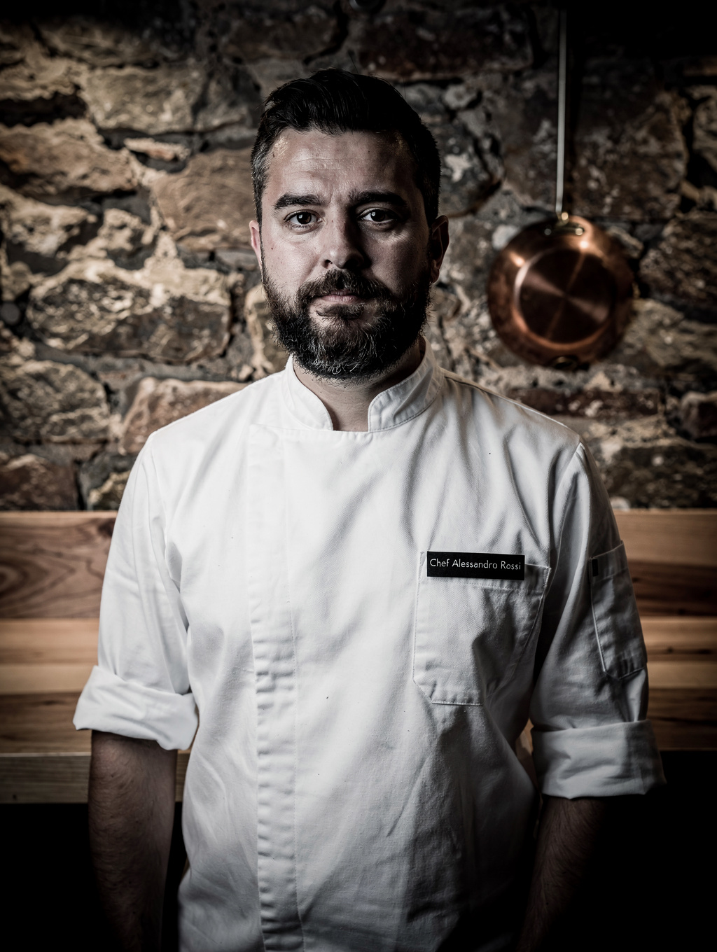 Chef Alessandro Conti in kitchen attire plating handcrafted pasta